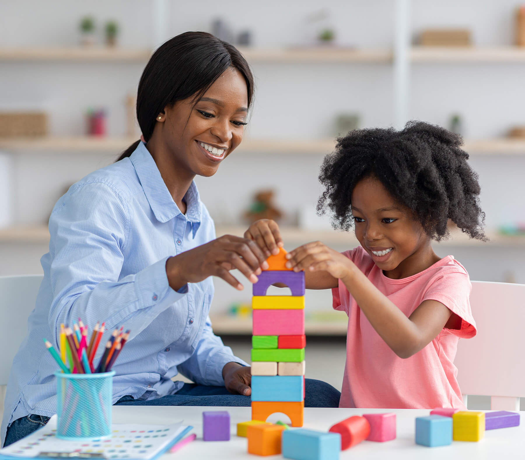 teacher and little girl black with blocks